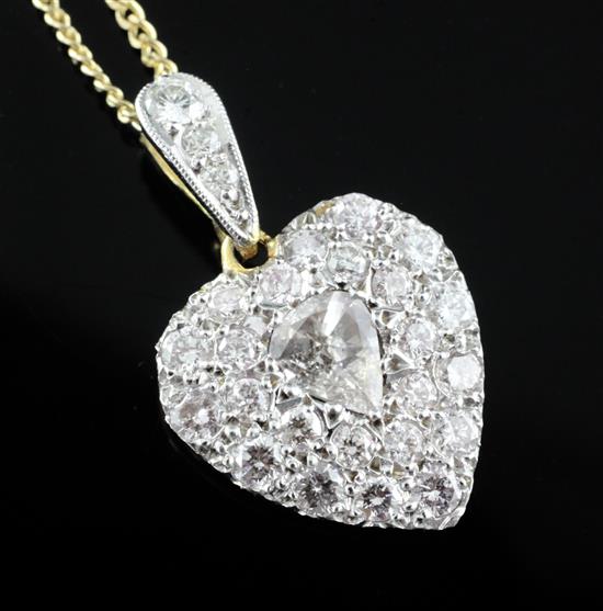 An 18ct gold and diamond encrusted heart shaped pendant with central pear shaped diamond, pendant 14mm.